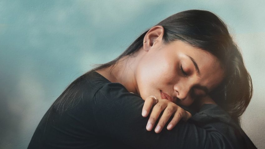 a woman sitting on a couch with her head on her hand